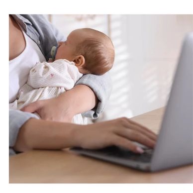 Mother breastfeeding at computer.    24/7 on call breastfeeding support.