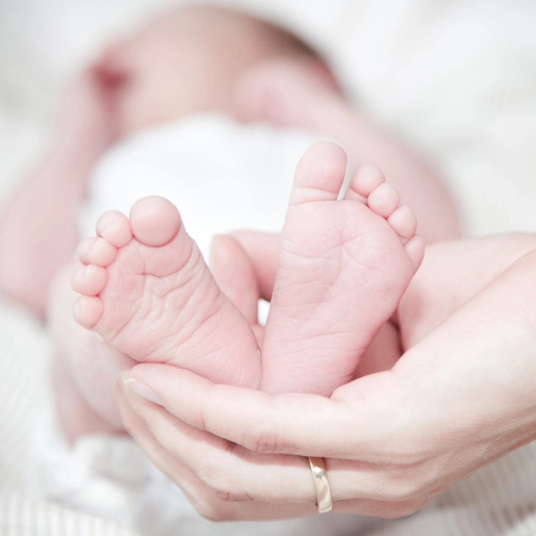 Doula holding infant feet