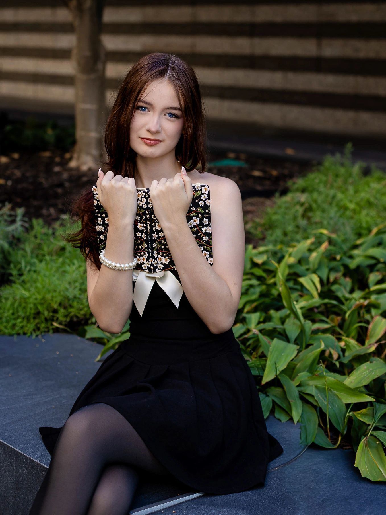 High school senior portrait at the Cleveland Museum of Art, seated outdoors in a black dress.