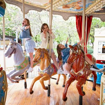 Three girls enjoying a carousel ride.