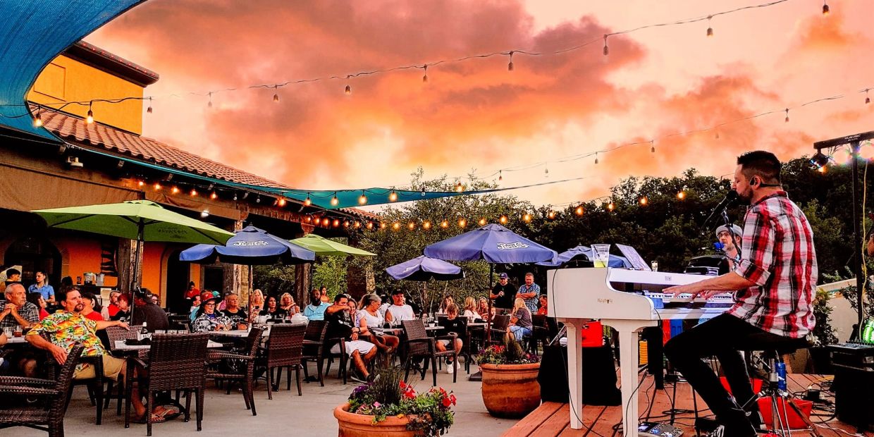 Outdoor live music performance at sunset with audience.