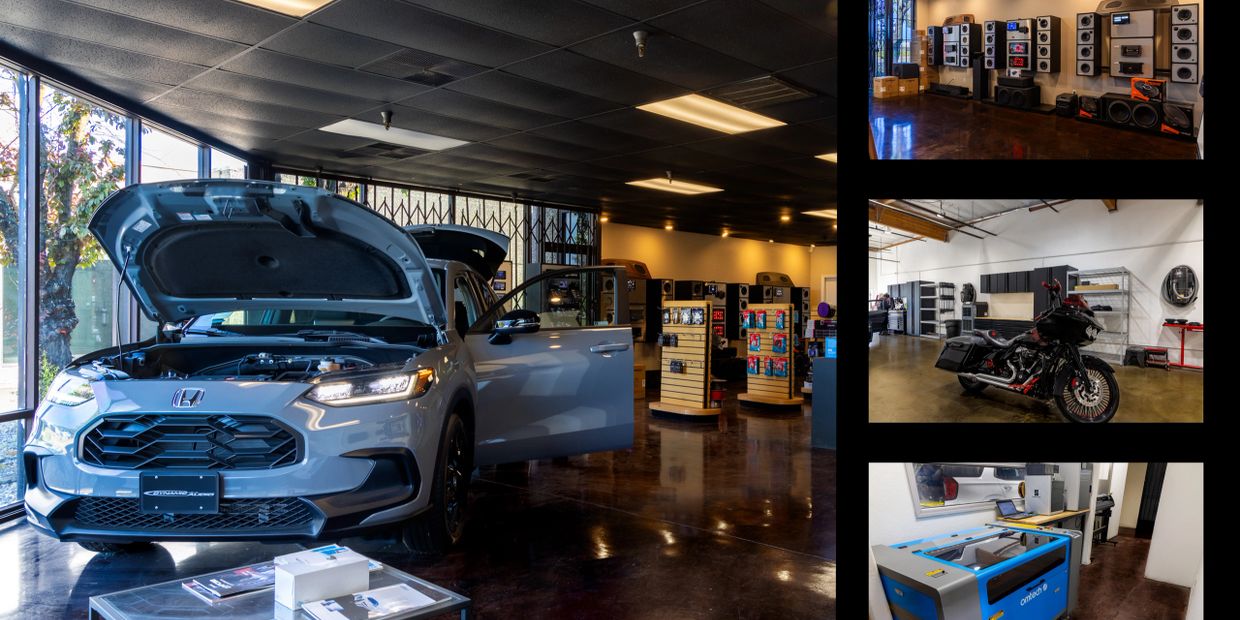 Car with open hood and door inside a showroom with gadgets.