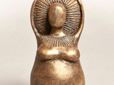 Bronze statuette of a faceless woman with a halo-like headdress.
