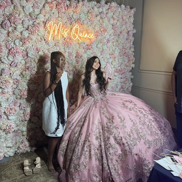 A teen taking a photo at her quinceanera with her best friend at the Photo Booth.
