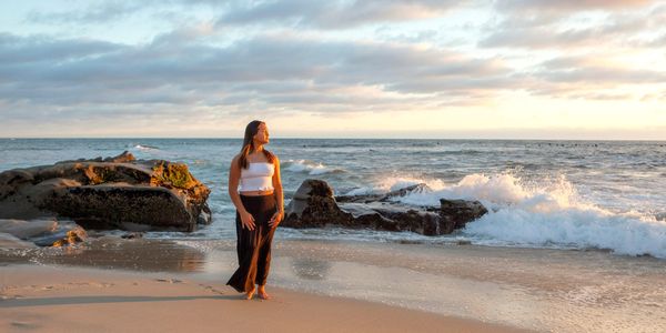 High school senior session at Windansea Beach in La Jolla at sunset with waves crashing.