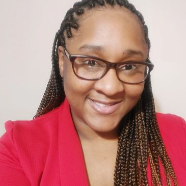 Smiling woman with glasses and braided hair wearing a red top.