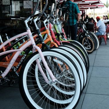 Row of colorful bicycles parked outside a cafe.