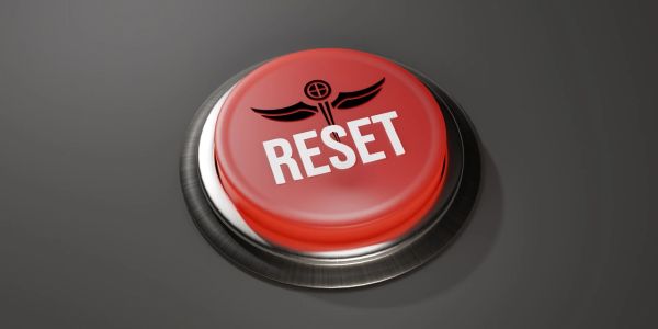 Red reset button with wings and target symbol.