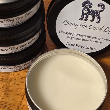 Natural dog paw balm containers on a wooden surface.