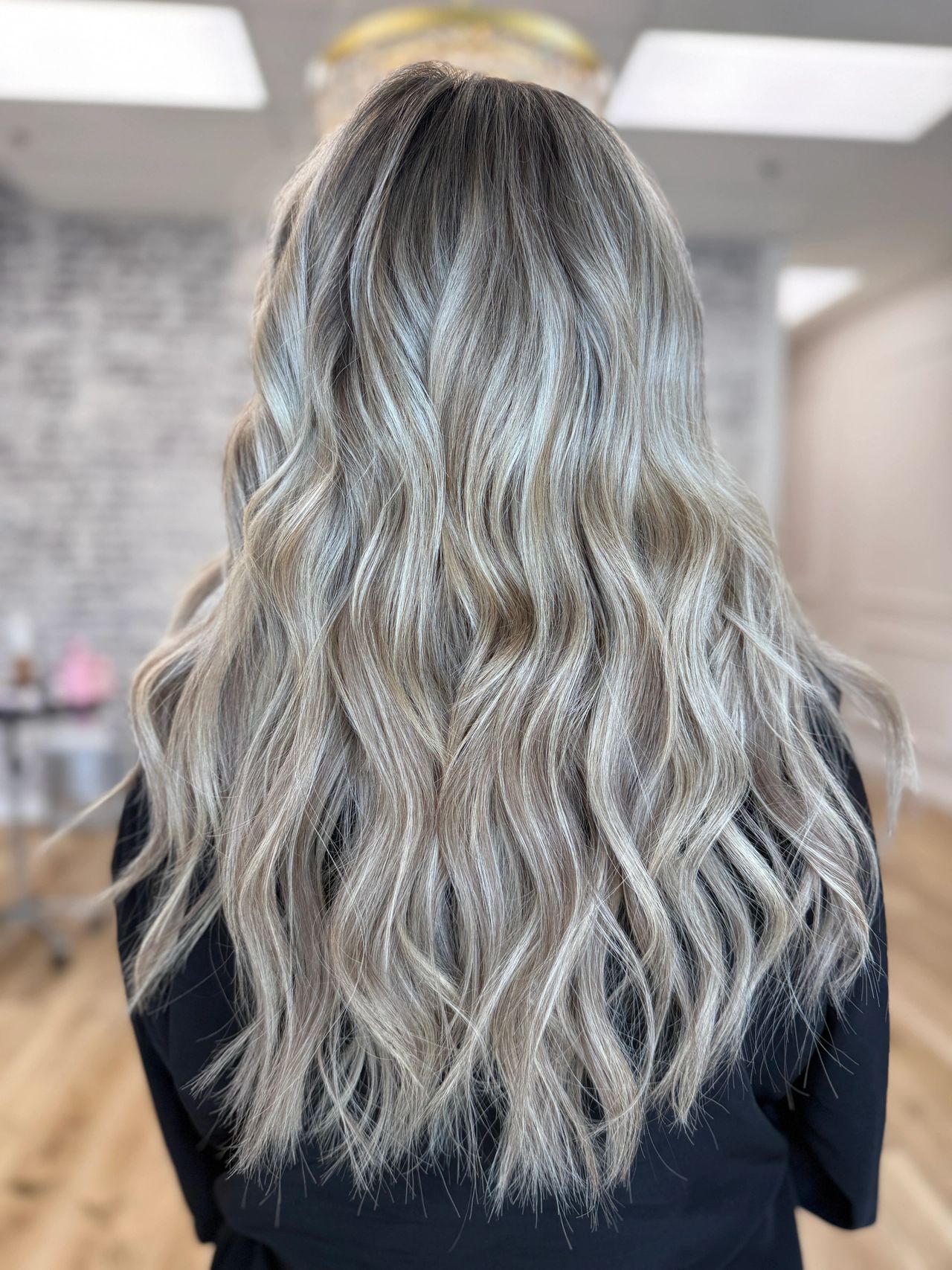 Icy silver blonde hair styled in soft flowing body waves
