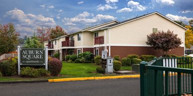Auburn Square apartment complex with manicured landscaping and cloudy sky.  Auburn WA