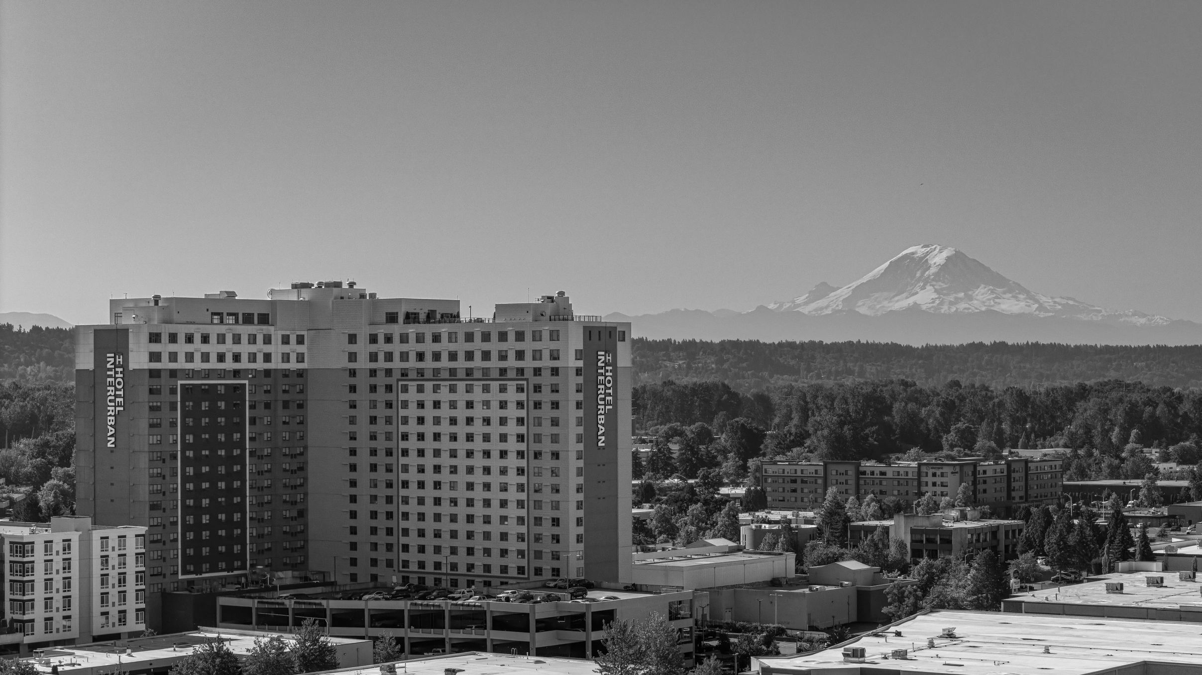 Hotel Interurban building with Mount Rainier in the background under clear blue sky.