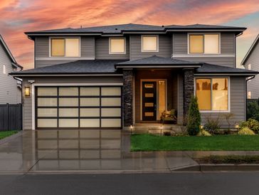 Modern two-story house with a sleek gray exterior at sunset.