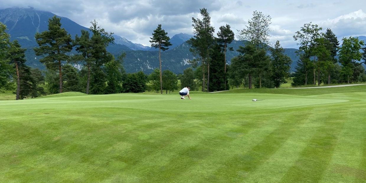 Reading a putt during a round of golf at Royal Bled Golf Club, Slovenia.