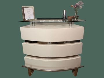 Modern bar cart with a glass top and decorative items.