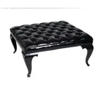 Black tufted leather ottoman with curved legs.