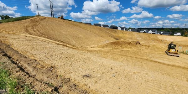 Construction site with earthmoving equipment on a clear day.