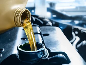 Pouring golden engine oil into a car engine.