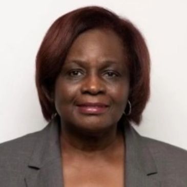 Professional portrait of a woman in a gray blazer with a neutral background.