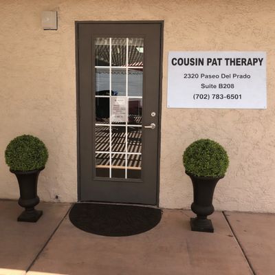 Entrance to Cousin Pat Therapy with decorative plants and a sign displaying contact info. This is Cousin Pat is Patrick Argiro. Las Vegas, Nevada Entrance
