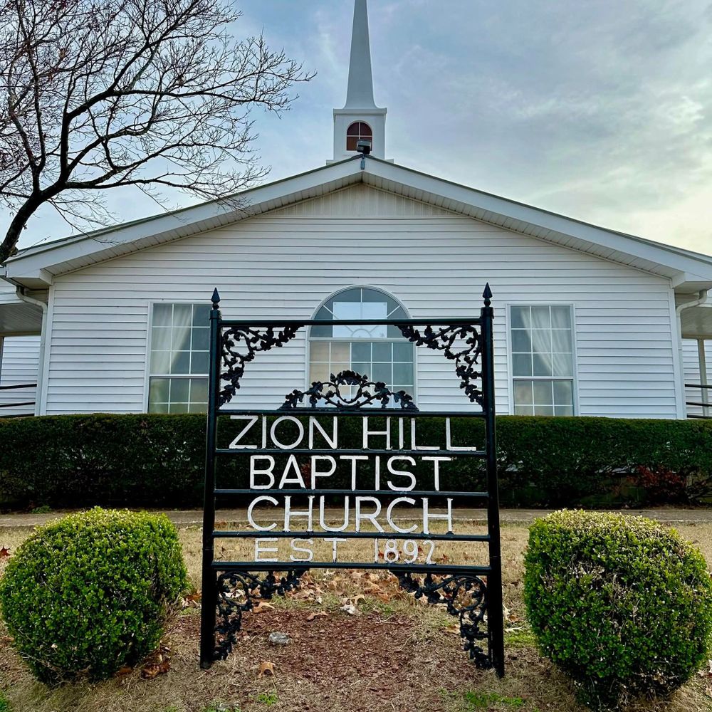 Front view of Zion Hill Baptist Church with a decorative sign.
