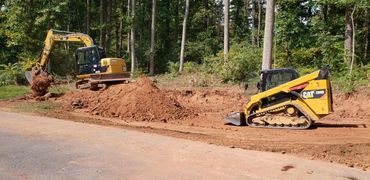 Cat excavator and Cat skidloader. Excavating dirt
