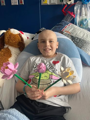 Mason holding three LEGO flowers.