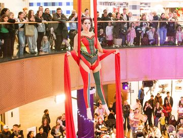 Aerial silk performer entertains a mall crowd.