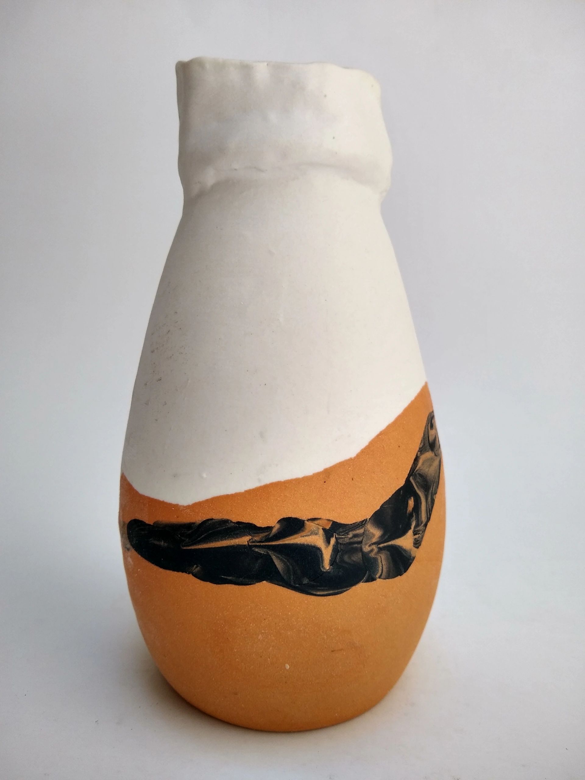 white and orange and black swirl vase