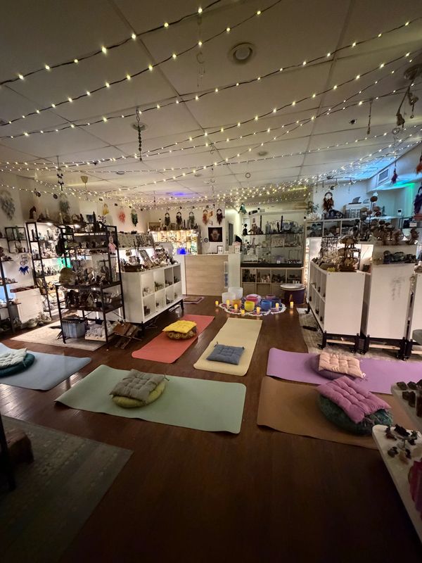 Cozy room with yoga mats, cushions, and string lights for relaxation or meditation.