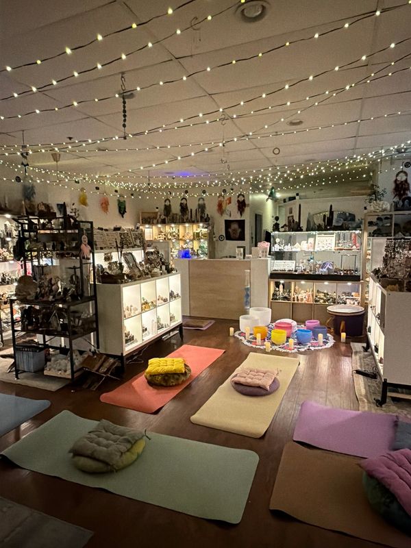 Cozy meditation space with mats, cushions, and calming lights inside a shop.