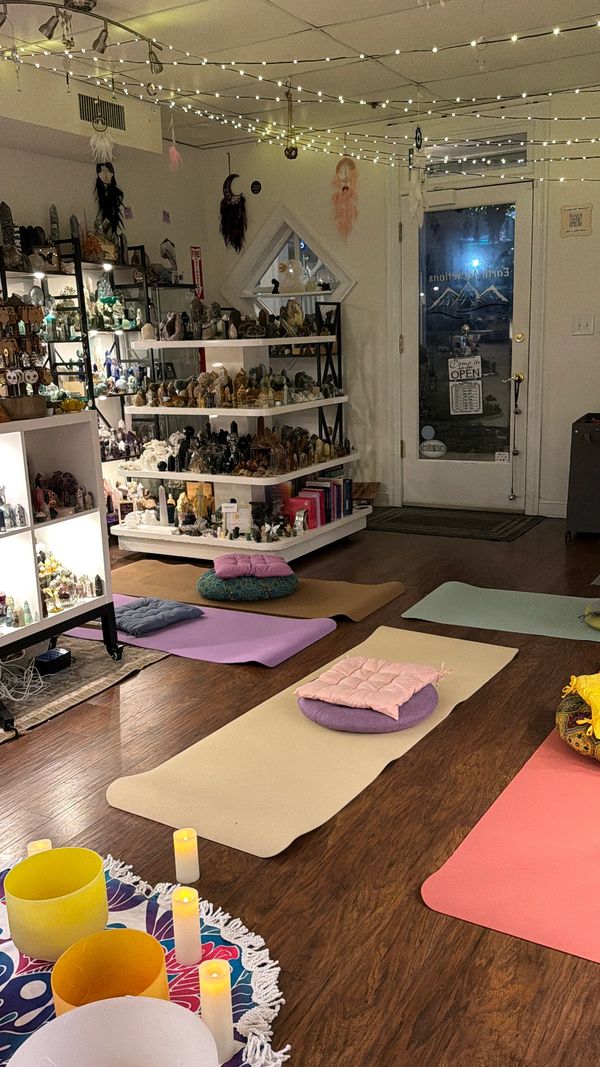 Cozy meditation space with mats, cushions, and soft string lights.