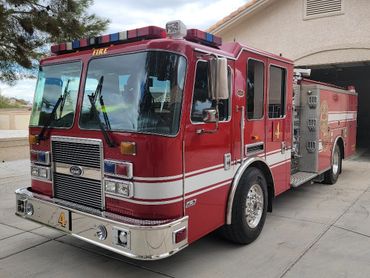 Red fire truck parked outside a residential garage.