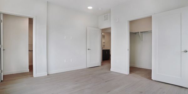 Empty modern room with white walls and light wood flooring.