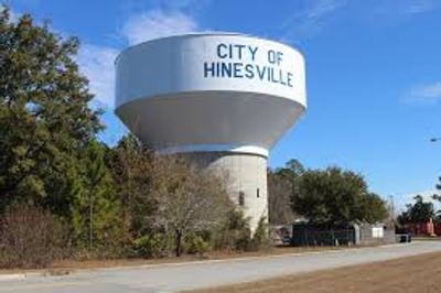 Water tower labeled 'City of Hinesville' against a blue sky.