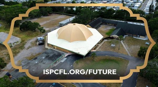 Aerial view of a unique dome-shaped building surrounded by roads and greenery.