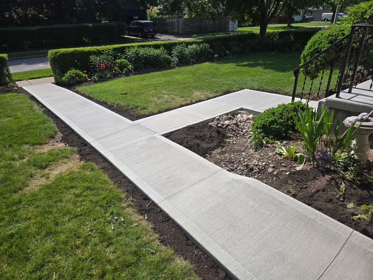 Beautiful broom swept concrete walkway to road and branching out to front porch
