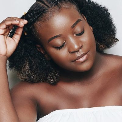 Close-up of a woman with natural curly hair and braids.