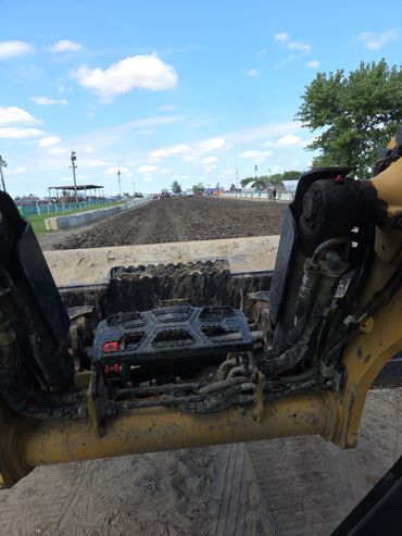 View from heavy machinery showing construction site and dirt landscape.
