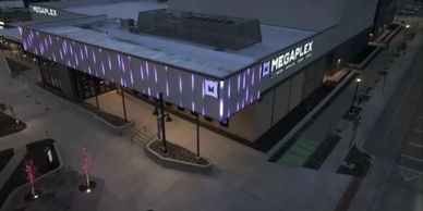 aAerial view of a commercial entertainment venue with purple permanent facade lighting