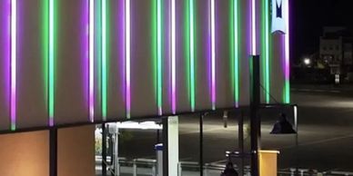 JellyFish Saber Series vertical light bars on a commercial building facade at night