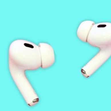 Close-up of white wireless earbuds on a blue background.