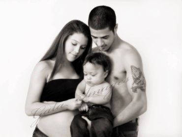 A loving family portrait with a mother, father, and child in black and white.