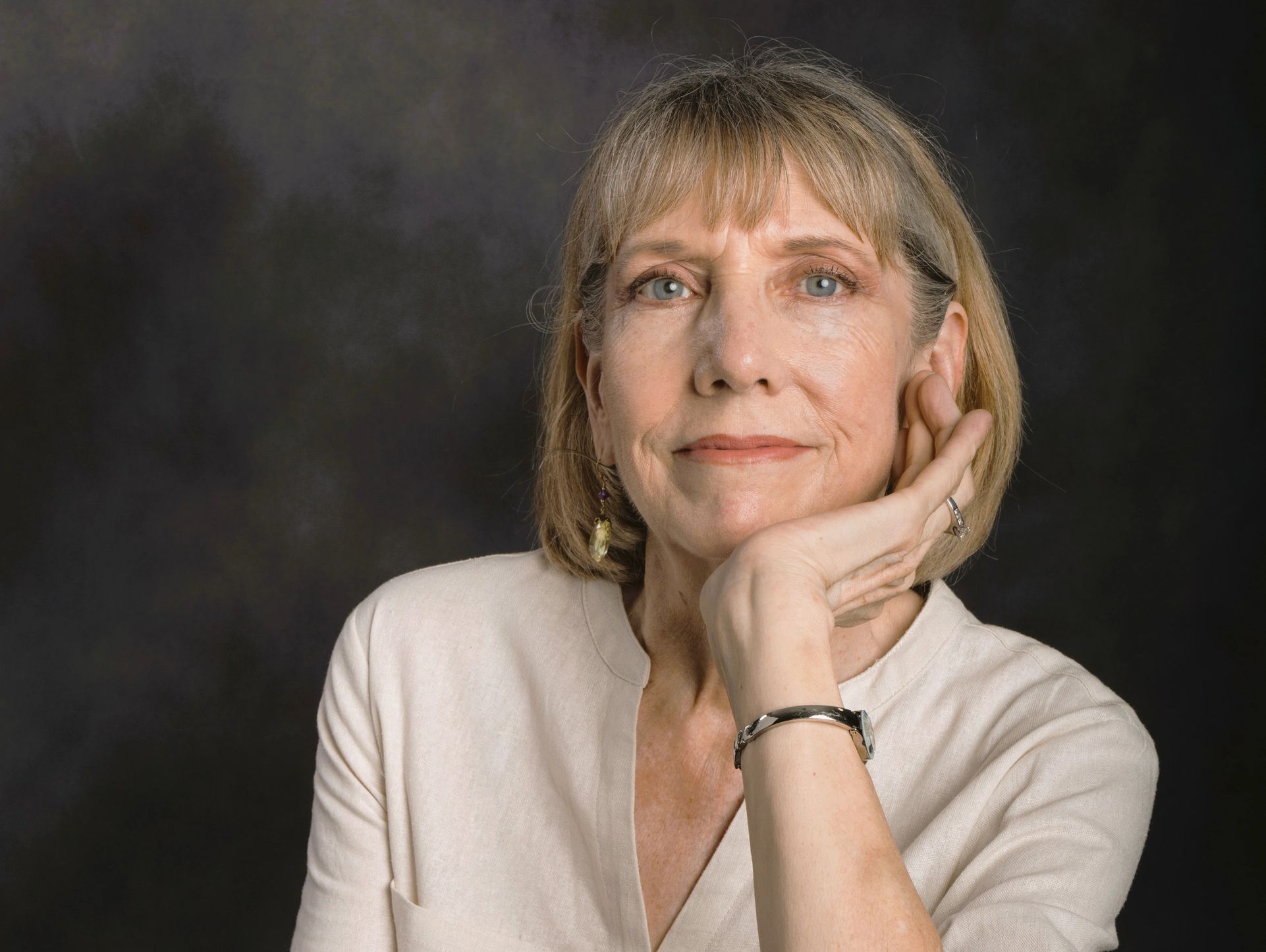 Color photo of the author today, resting her chin on the open palm of her left hand.