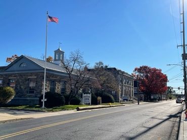 A street with a building and an american flag on the corner.