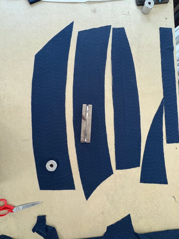 Cut fabric pieces arranged for garment sewing on a worktable.