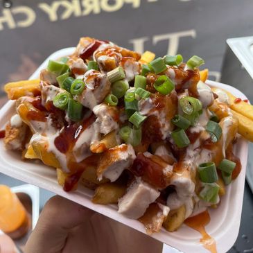 Loaded fries topped with grilled chicken, sauces, and green onions.