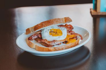 A tasty bacon, egg, and cheese sandwich on white bread.