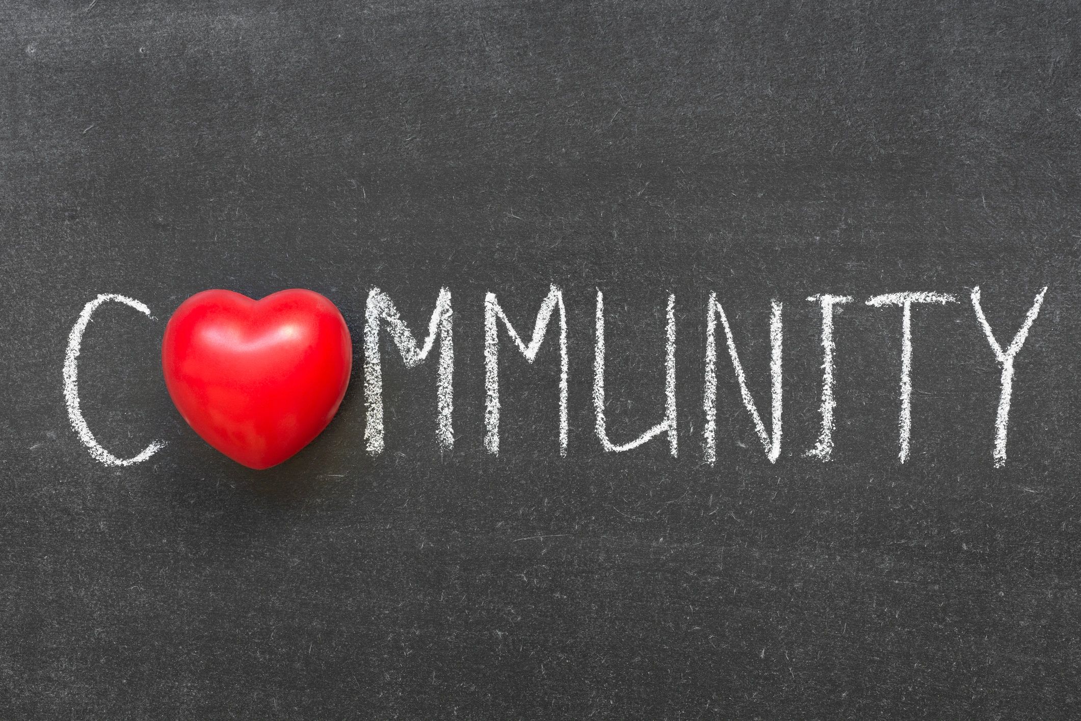 Red heart replaces 'O' in the word 'Community' on chalkboard.