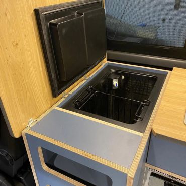 Compact built-in mini fridge with open door.